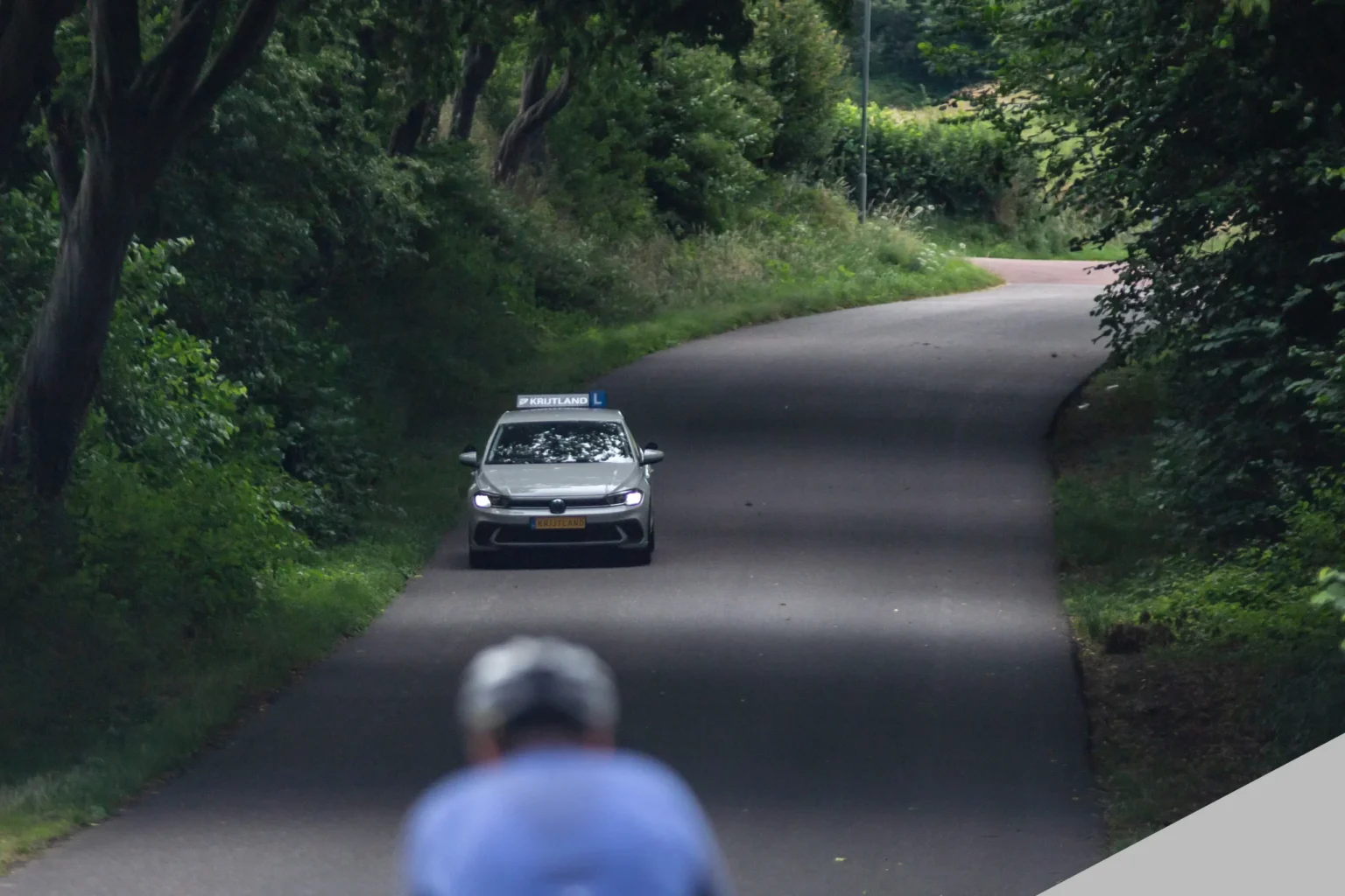 Lesauto van Autorijschool Krijtland op een bosweg in het Limburgse heuvelland